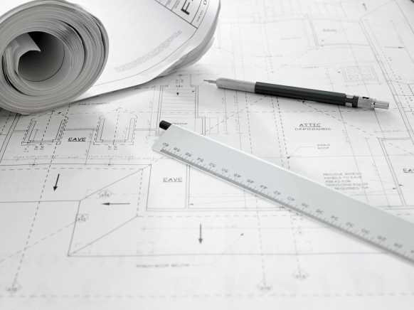Set of rolled plans and a ruler what architects call a scale and .05 mechanical pencil